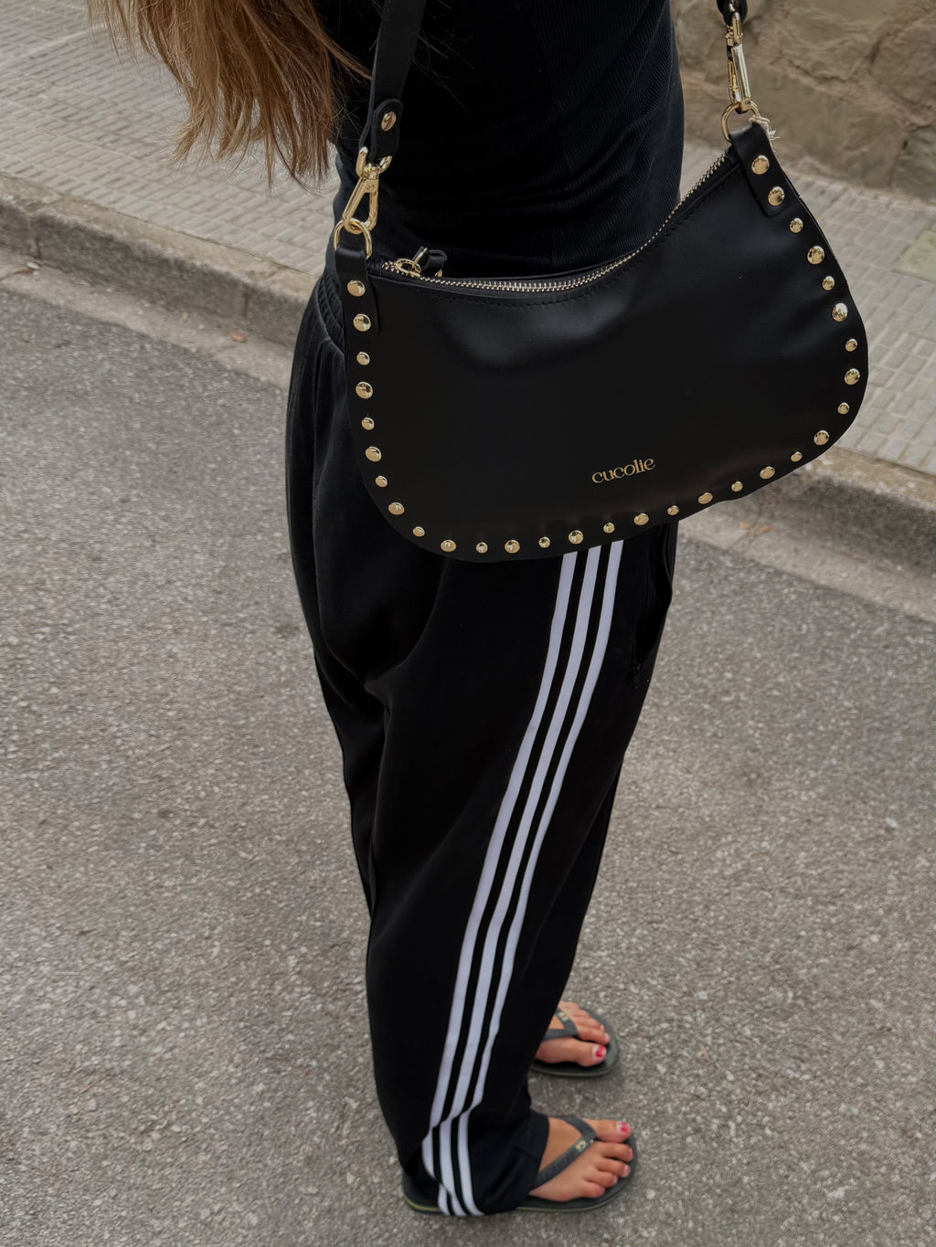 Bolso Roxy negro con tachuelas, llevado con pantalón deportivo — Cucolie